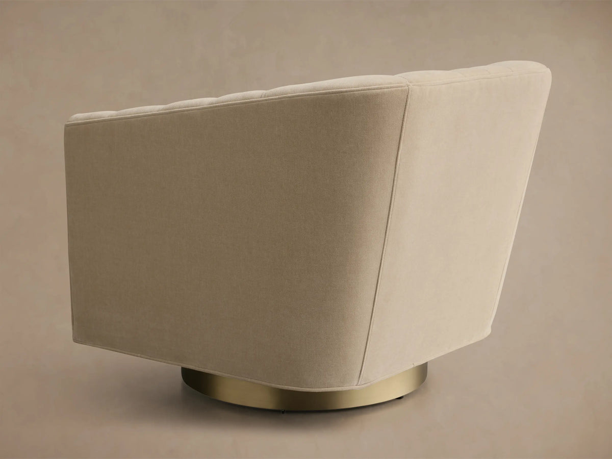 Side profile of a beige Ellison Channel-Stitched Metal Plinth Swivel Chair with channel-stitching and a gold metal plinth base.