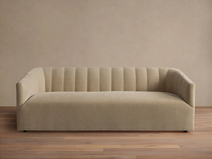 Pale tan Ellison Channel-Stitched Sofa, front view, with vertical channels on backrest & inner arms, on wood floor against light wall.