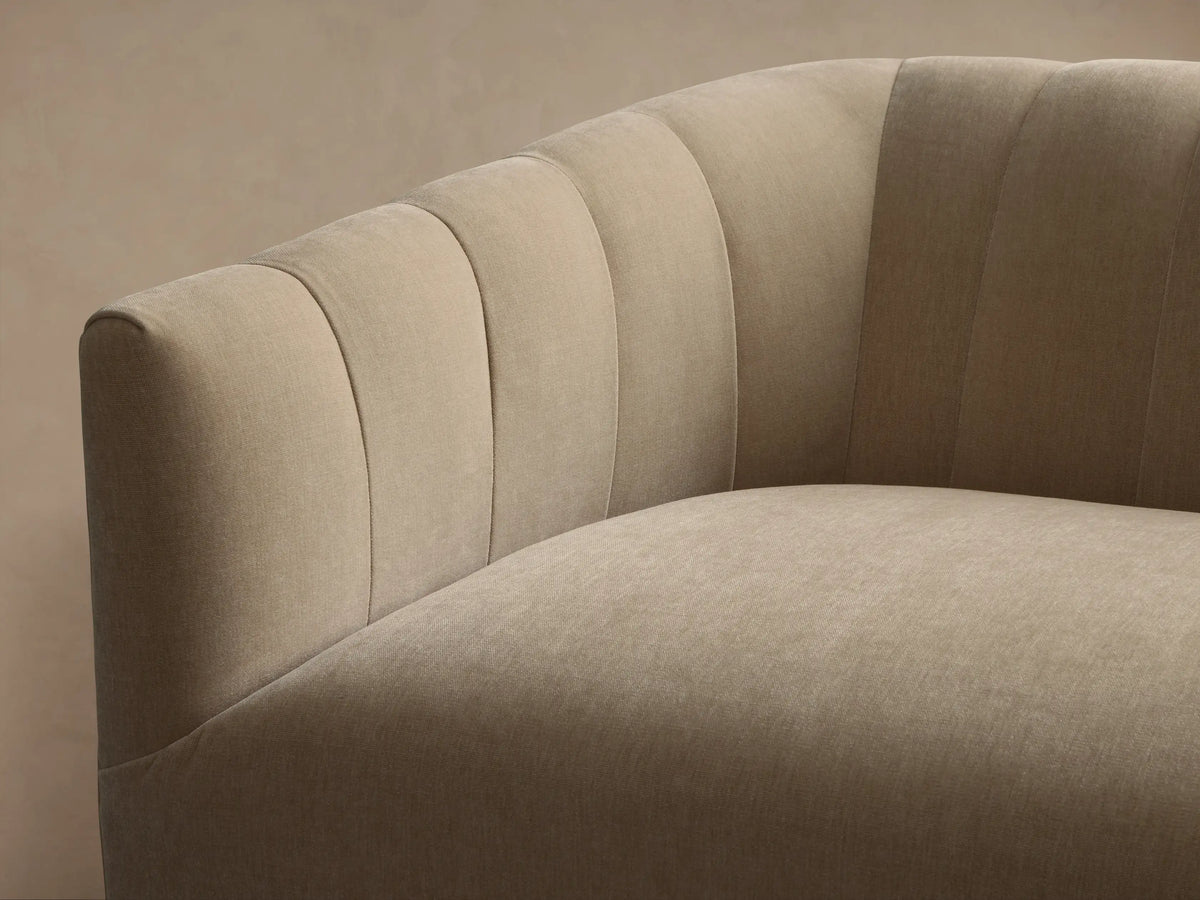 Light beige Ellison Channel-Stitched Sofa with vertical channel tufting on its curved backrest and arms, shown angled.