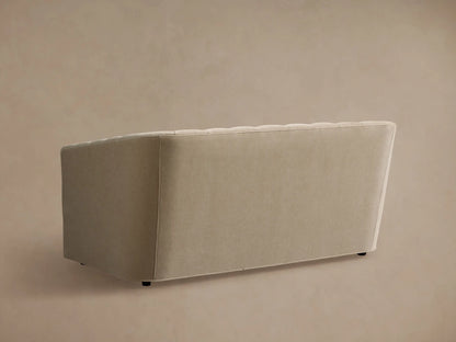Close-up of the light beige Ellison Channel-Stitched Sofa, showing the curved back and armrest with vertical stitching.