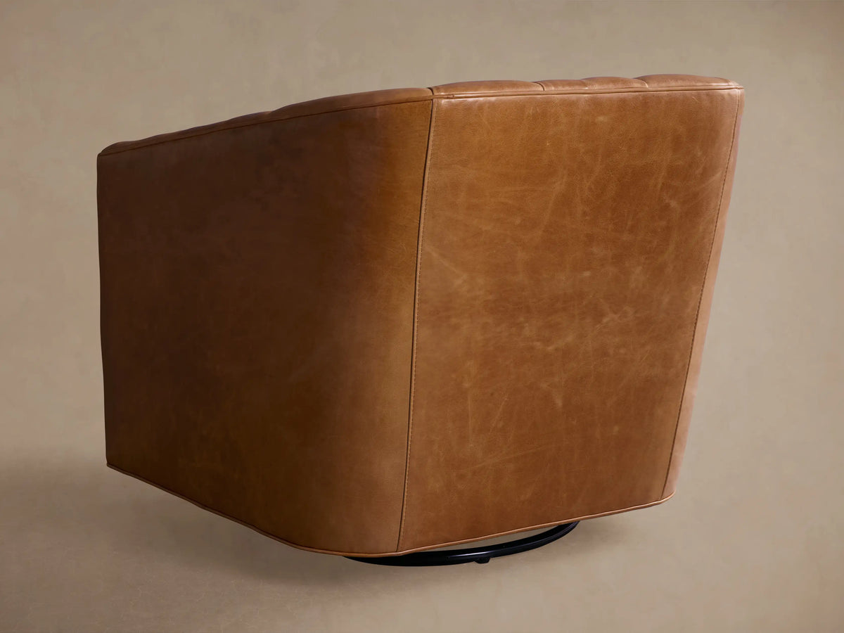 Tan leather Ellison Channel-Stitched Swivel Glider, side view. Features curved design & visible channel stitching on back.