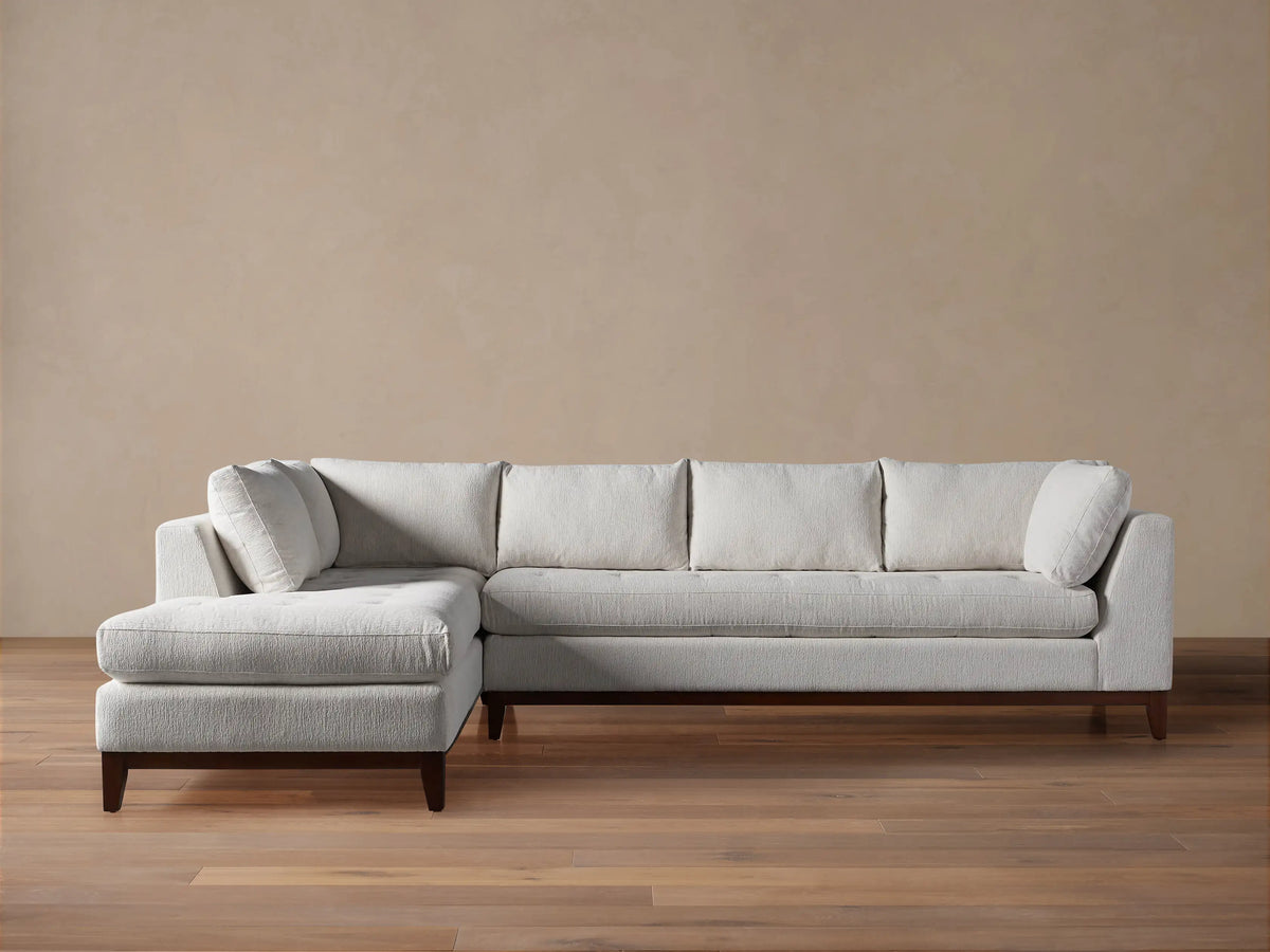 Bryden Two-Piece Daybed Sectional in light grey textured fabric with a left-facing chaise and dark wood base.