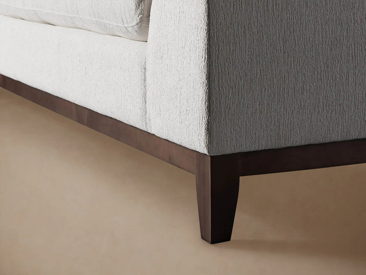 Close-up of Bryden Two-Piece Daybed Sectional, showing its light grey, highly textured fabric on a cushion and arm.