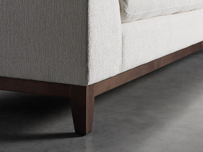 Close-up of Bryden Two-Piece Daybed Sectional. Light neutral textured fabric on armrest, plush back and seat cushions.