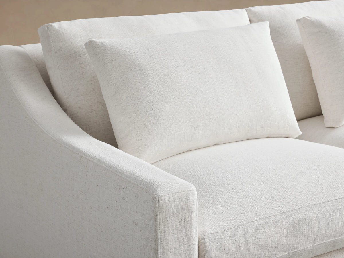 Ashby Three-Piece Corner Sectional in light fabric, set on a wooden floor against a neutral wall. Features cushioned seats and backrests.