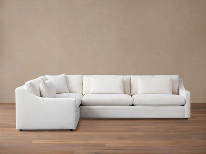 Ashby Two-Piece Sectional in white fabric, with clean lines and plush back and seat cushions, set on a wooden floor.