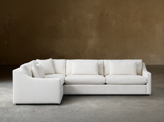 Ashby Two-Piece Sectional in white fabric, with clean lines and plush back and seat cushions, set on a wooden floor.
