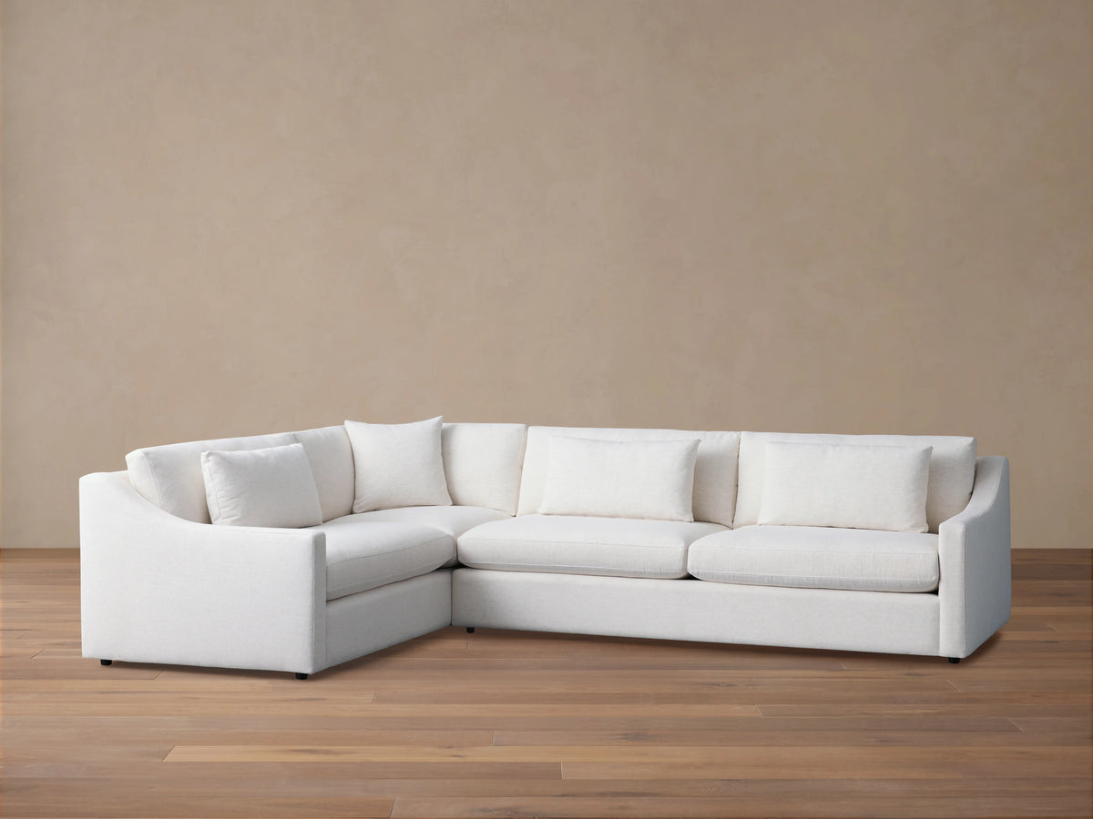 Ashby Two-Piece Sectional in white fabric, with clean lines and plush back and seat cushions, set on a wooden floor.