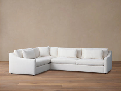 Ashby Two-Piece Sectional in white fabric, with clean lines and plush back and seat cushions, set on a wooden floor.