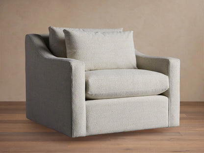 Ashby Swivel Chair in light beige textured fabric, with a plush seat and back cushion, angled on a wooden floor.