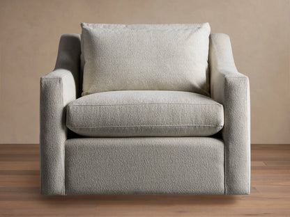 Ashby Swivel Chair in light beige textured fabric, with a plush seat and back cushion, angled on a wooden floor.