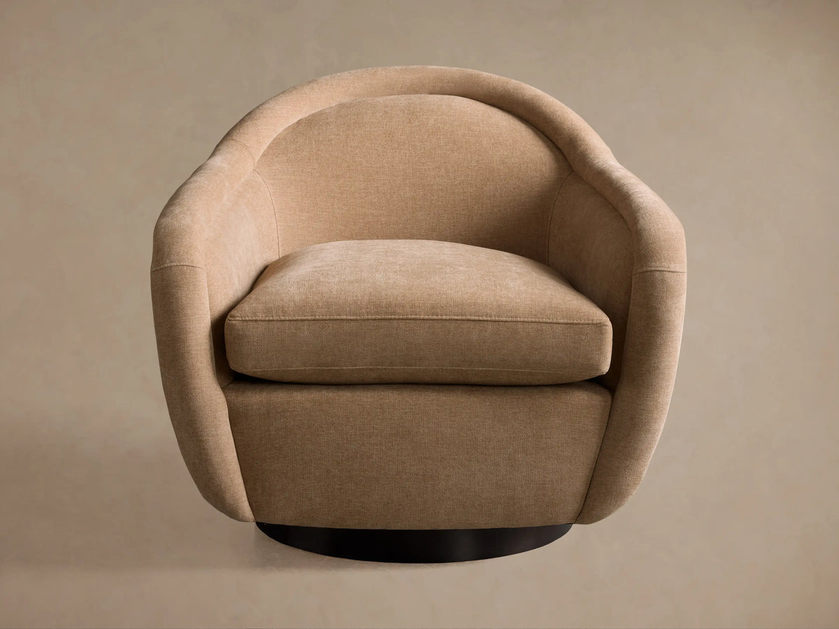 Two speckled brown Ashbury Swivel Chairs flank a light beige sofa in a wood-paneled living room.