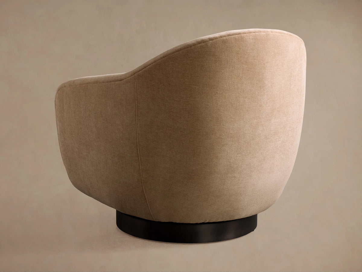 Close-up of Ashbury Swivel Chair's textured light brown fabric seat cushion and curved upholstered backrest.