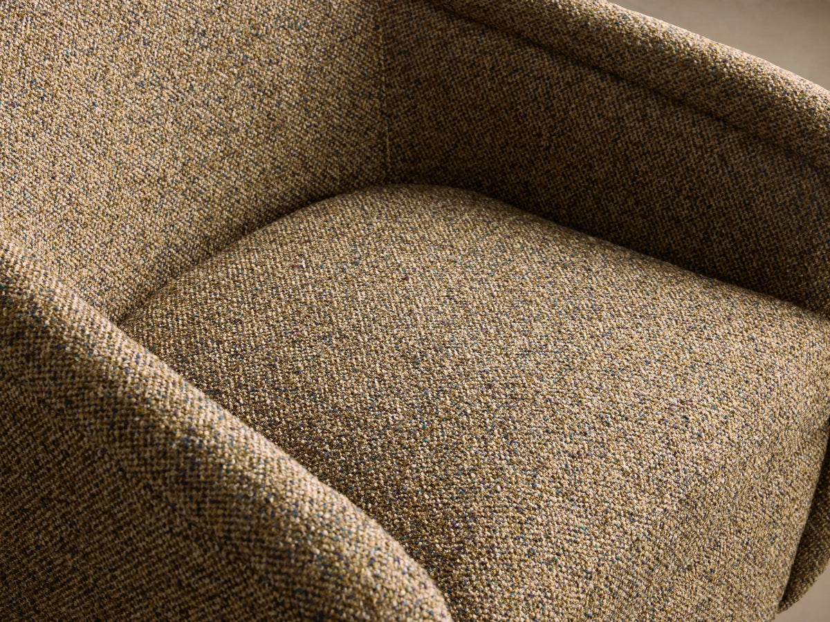 Ashbury Swivel Chair, rounded, upholstered in textured brown-green tweed fabric, with a black swivel base, on wood floor.