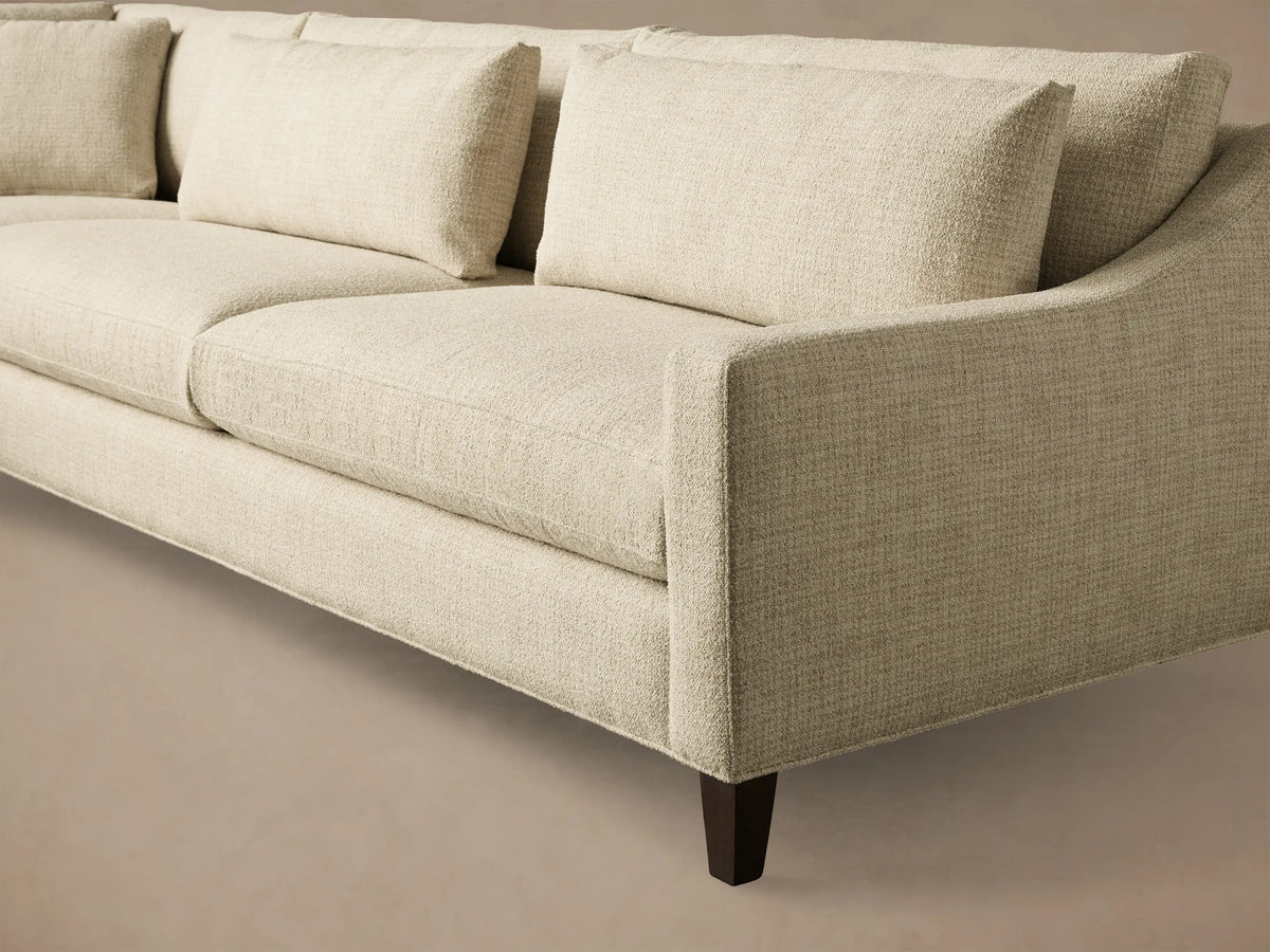 Front view of a light beige L-shaped Ashby Elevated Two-Piece Sectional with plush cushions and mocha finish feet.
