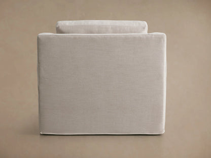 Ashby Slipcovered Swivel Chair in beige fabric on a wooden floor, featuring plush seat and back cushions, with a modern, rounded arm design.