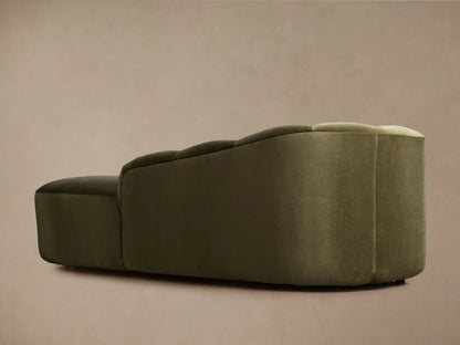 Amira Daybed, close-up of the olive green velvet upholstery. Features a smooth, rounded arm and soft, fluted back cushions.