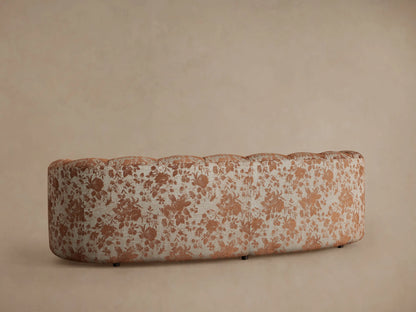 Close-up of Amira Sofa in Cinnamon. Plush solid cinnamon seat cushion beside plump back cushions with a cinnamon floral pattern.