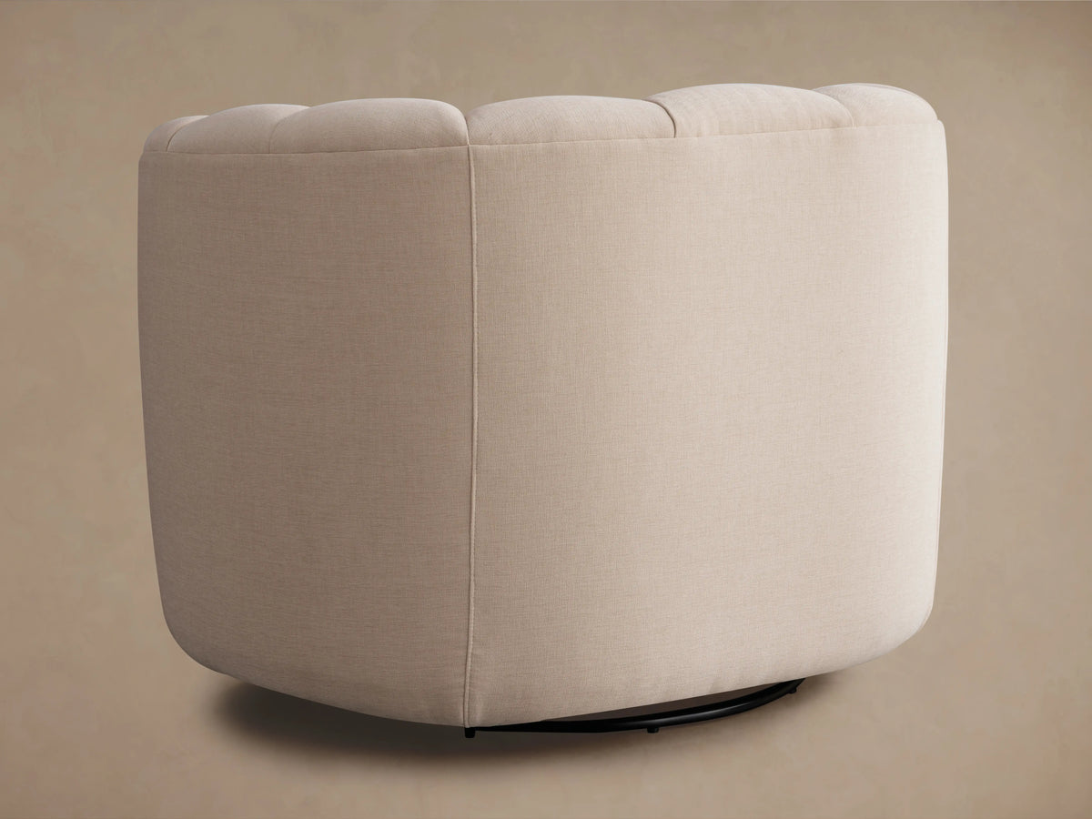 Amira Swivel Chair in Avery Blush fabric, showcasing its curved, plush backrest and soft, durable upholstery in a neutral tone.