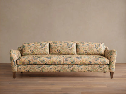 Front view of the Alina Sofa with beige upholstery in a multi-colored floral and paisley pattern, three back cushions, and dark wood legs.