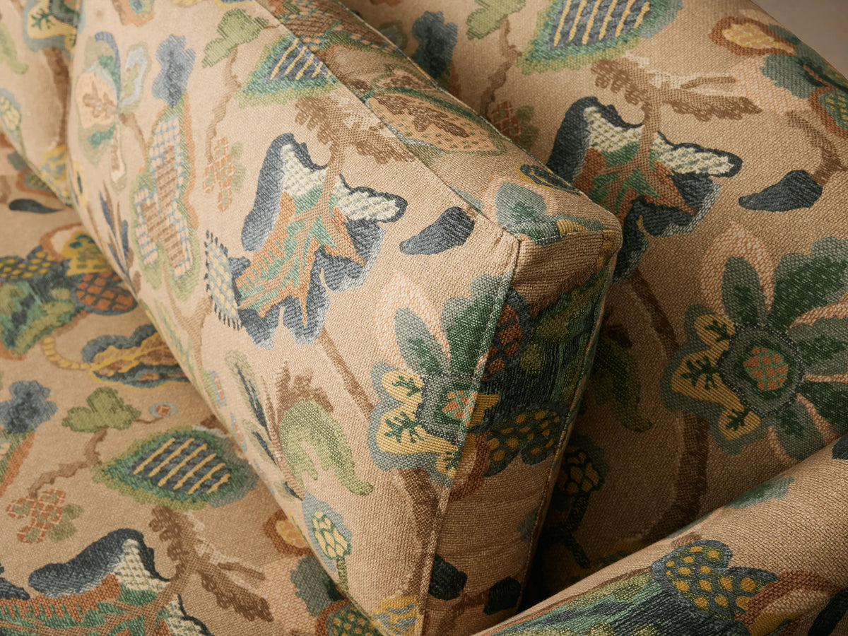 Front view of the beige multicolored floral patterned Alina Sofa with three seat cushions, three back cushions, and dark wood legs.
