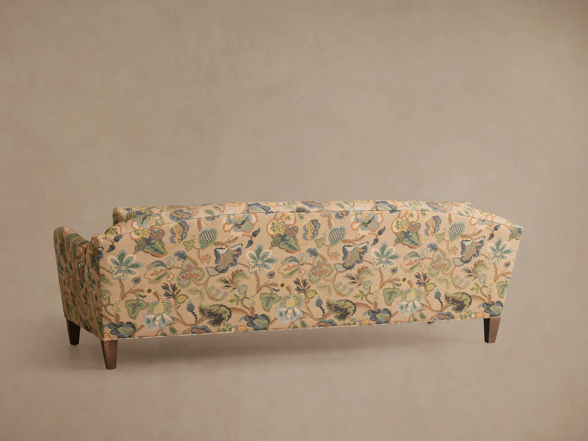 Close-up of the beige fabric on the Alina Sofa, featuring an intricate botanical and chinoiserie pattern in greens, blues, and browns.