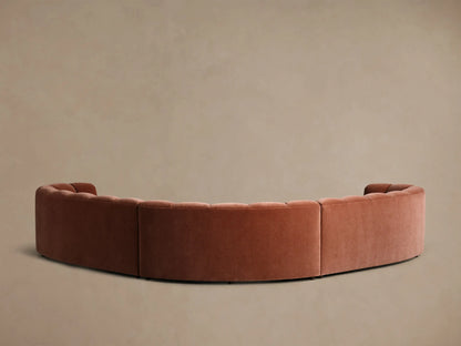 Rear view of the rust Amira Three-Piece Corner Sectional, showing a continuous curved back with vertical tufting.