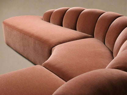 Front view of the terracotta pink Amira Three-Piece Bumper Sectional with a curved design and channel tufted back.