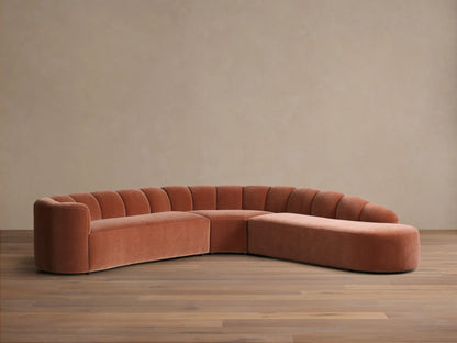 Front view of the terracotta velvet Amira Three-Piece Bumper Sectional with a curved design and channel-tufted back.