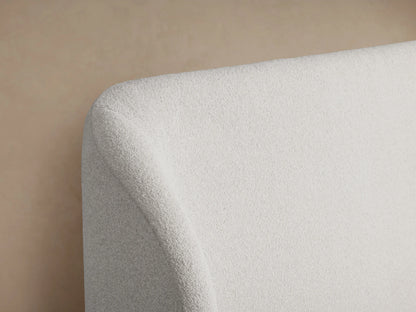 Adalynn Bed with plush white upholstered headboard and bed frame, displayed against a neutral beige background.