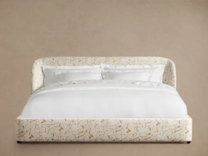 Adalynn Bed with an upholstered headboard featuring a floral pattern in soft tones. It includes white bedding and pillows.