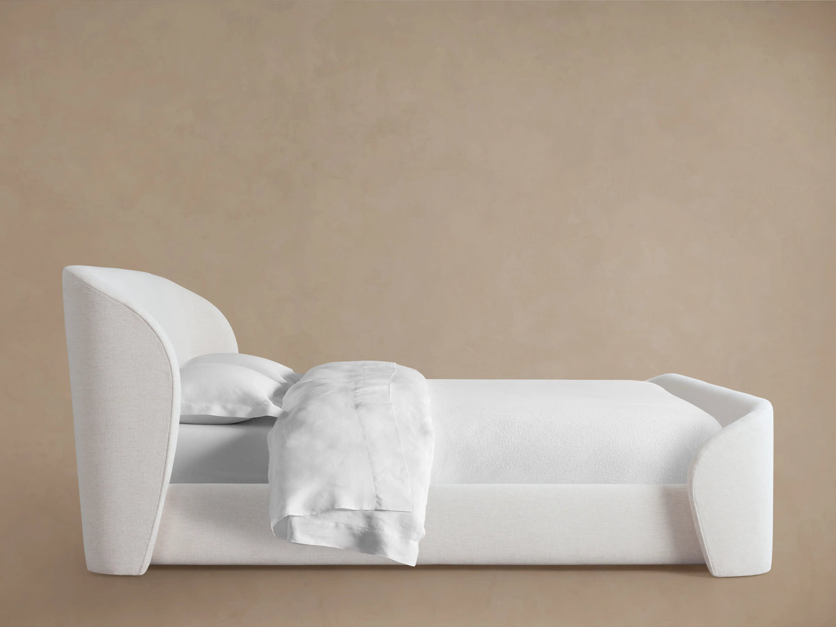 Adalynn Bed with High Footboard, featuring a plush white upholstered headboard and matching footboard, on wooden flooring.