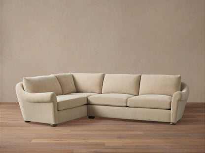 Beige Archwood Two-Piece Sectional on wooden floor, featuring plush cushions, L-shaped design, rolled arms, and dark wooden legs.