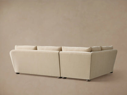 Beige two-piece sectional sofa with a soft fabric finish, featuring plush backrests and cushioned seats. Curved armrest adds elegance.