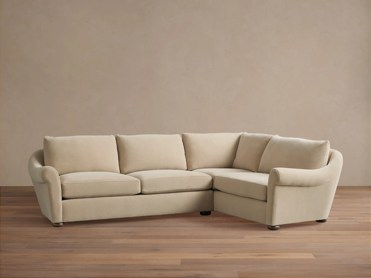 Beige Archwood Two-Piece Sectional on hardwood floor; three seat cushions, rounded arms, and plush backrests in bright, neutral room.
