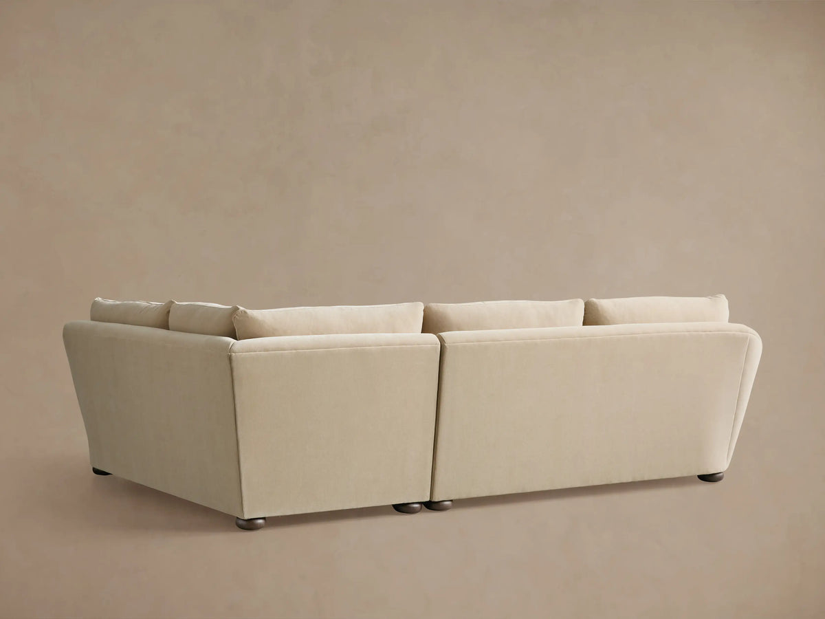 A close-up of the Archwood Two-Piece Sectional shows a soft beige fabric with plush cushions and gently curved armrests.