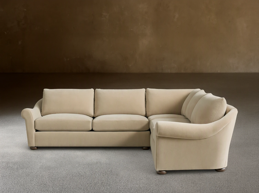 Archwood Three-Piece Corner Sectional in cream fabric, features rounded arms, plush back and seat cushions, on a wood floor.