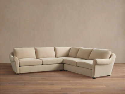 Archwood Three-Piece Corner Sectional in cream fabric, features rounded arms, plush back and seat cushions, on a wood floor.