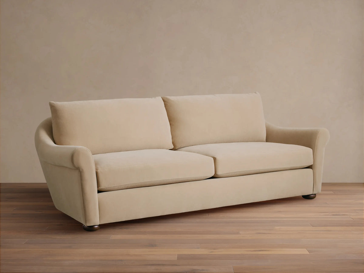 Front view of Cream Archwood Sofa with two seat and back cushions, rolled arms, and dark feet.