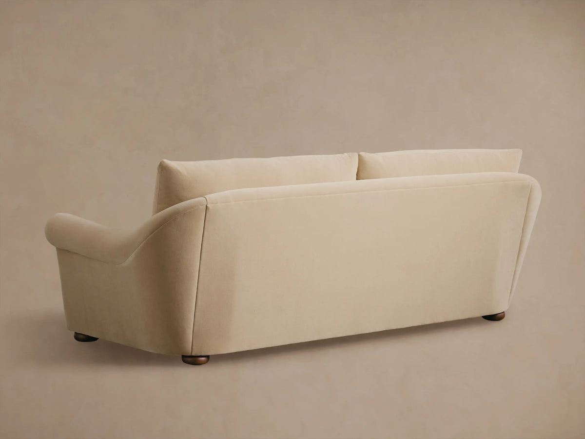 Close-up of a beige Archwood Sofa, showing the rolled armrest, seat cushions, and soft fabric.