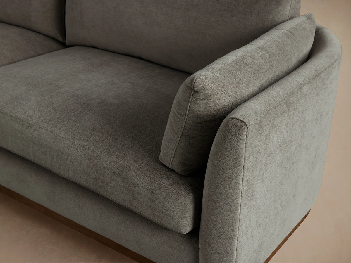 Bainbridge Sofa. Contemporary grey fabric sofa with a natural wood base, two seat cushions, two back cushions, and arm pillows.