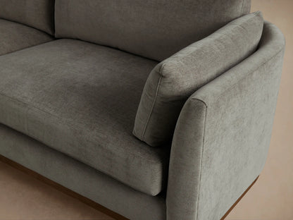 Bainbridge Sofa. Contemporary grey fabric sofa with a natural wood base, two seat cushions, two back cushions, and arm pillows.