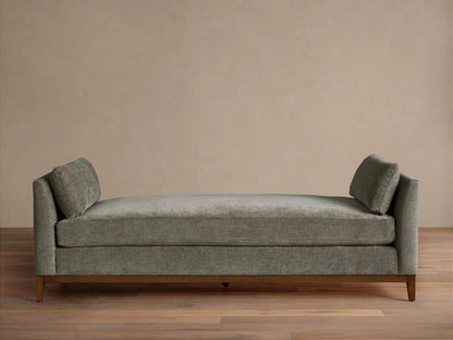 Bainbridge Daybed, gray-green textured fabric, two angled back cushions, dark wood base on wood floor.