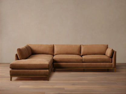 Bainbridge Two-Piece Bumper Sectional in warm brown leather, L-shaped with a left-hand chaise. Sits on a wooden floor.