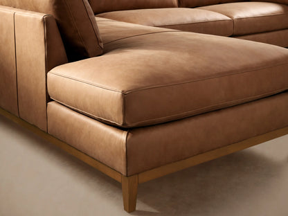 Bainbridge Two-Piece Bumper Sectional in camel leather, left-facing chaise, with light wood frame, on wood floor.
