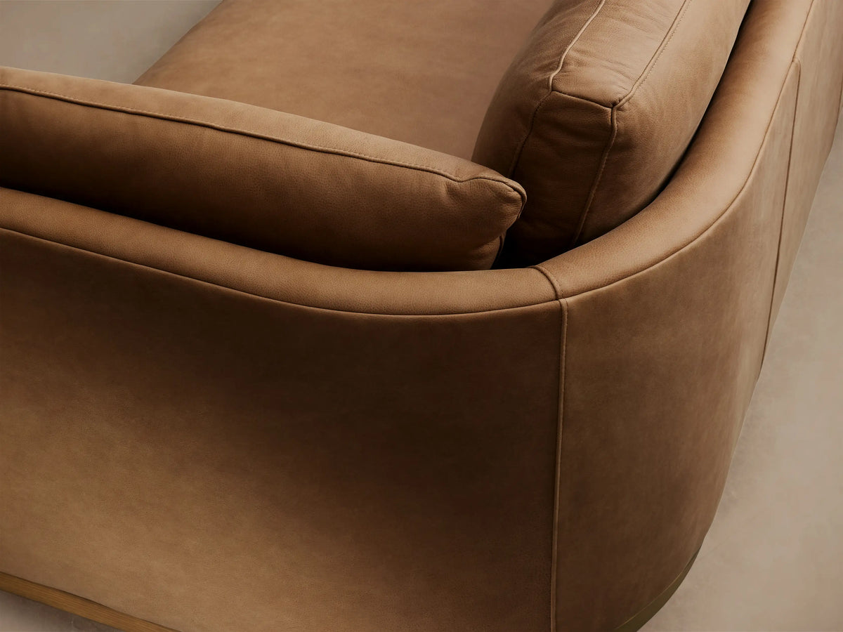 Modern Bainbridge Leather Sofa: Warm tan leather, 2 seat & back cushions, wide arms, wood base on wood floor.
