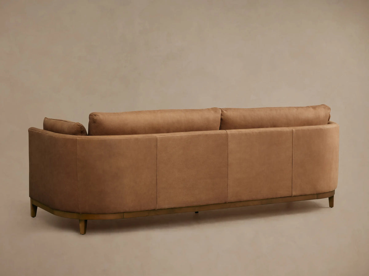 Close-up of the Bainbridge Leather Sofa, showing its curved armrest and back in rich, smooth camel-colored leather.