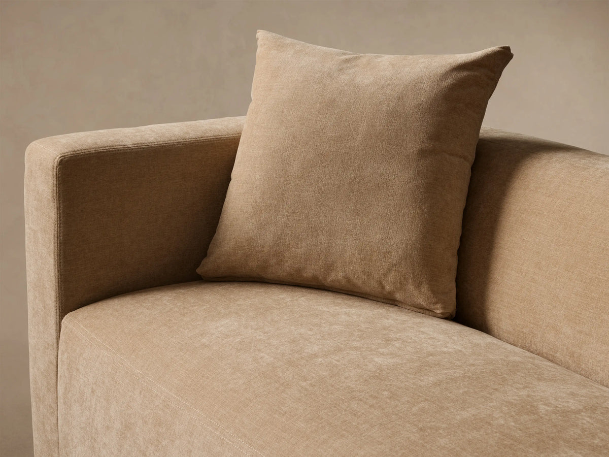 Front view of a beige Brady Sofa with two matching throw pillows on a wooden floor.