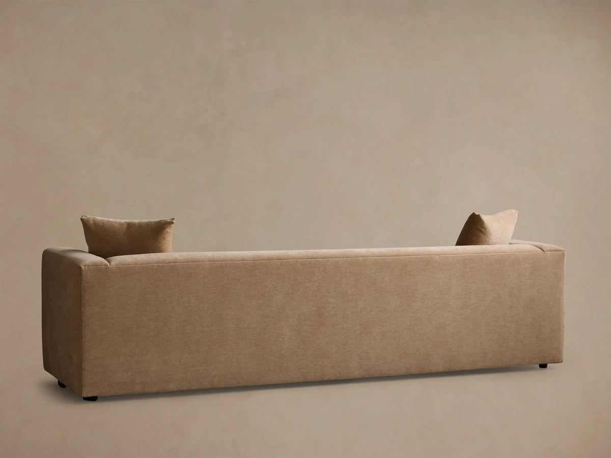 Close-up view of the tan Brady Sofa's textured fabric on the seat, armrest, and a square throw pillow.