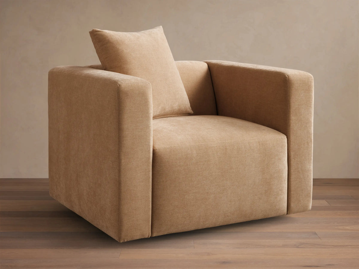 Front view of the tan Brady Swivel Chair, featuring a square, modern design with thick arms and a matching back cushion.